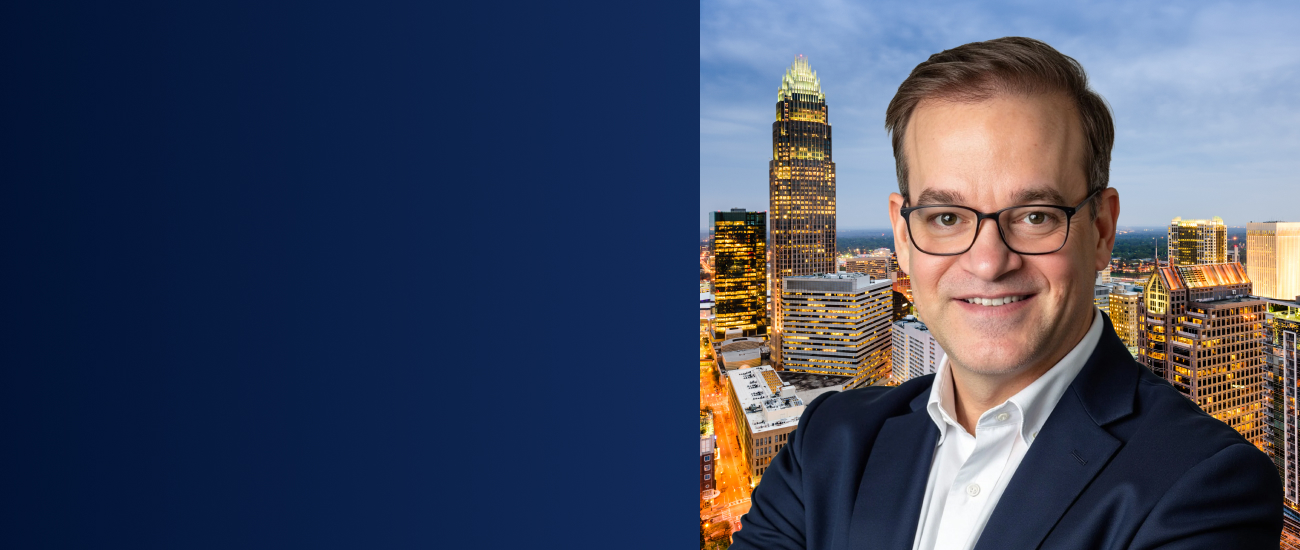 Michael D. Maurer pictured against the Charlotte skyline at dusk.